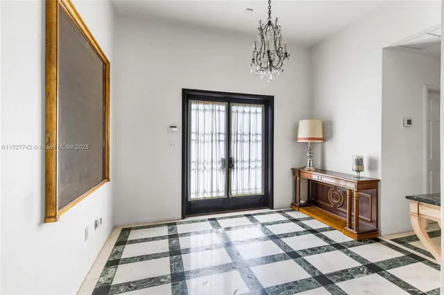 a view of a hallway with windows and chandelier