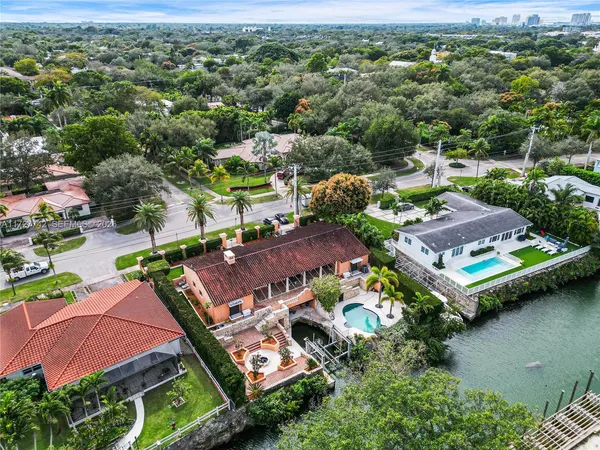 an aerial view of a house with a garden and lake view