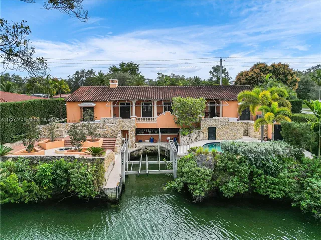 an aerial view of a house with swimming pool a patio and garden