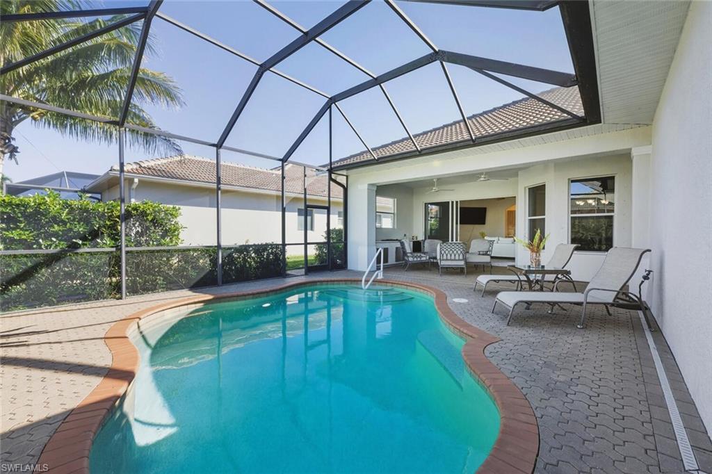 10800 Fieldfair Drive Naples, FL 34119 - Photo 1 of 47 Outdoor pool with a sunroom, a lanai, a patio area, and outdoor lounge area