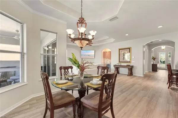 a dining room with furniture a chandelier and wooden floor