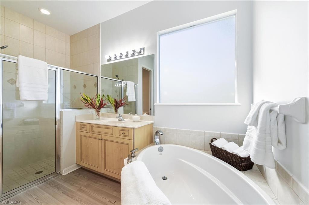 10800 Fieldfair Drive Naples, FL 34119 - Photo 23 of 47 Full bathroom with a bath, a stall shower, vanity, and light wood finished floors