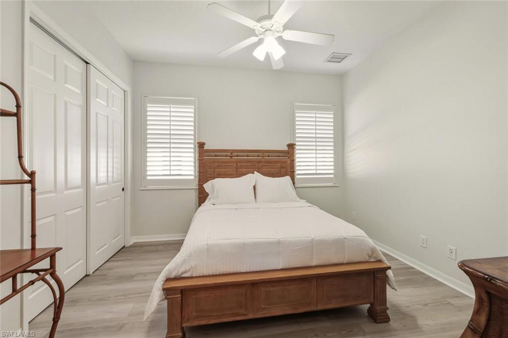 10800 Fieldfair Drive Naples, FL 34119 - Photo 33 of 47 Bedroom with a ceiling fan, light wood-style flooring, and a closet