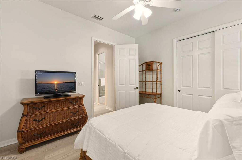 10800 Fieldfair Drive Naples, FL 34119 - Photo 34 of 47 Bedroom with light wood-type flooring, ceiling fan, and a closet