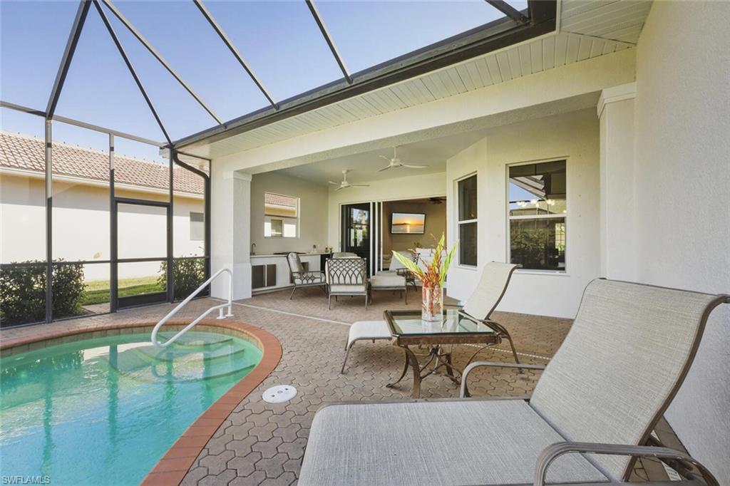 10800 Fieldfair Drive Naples, FL 34119 - Photo 39 of 47 Outdoor pool with glass enclosure, a sunroom, and a patio