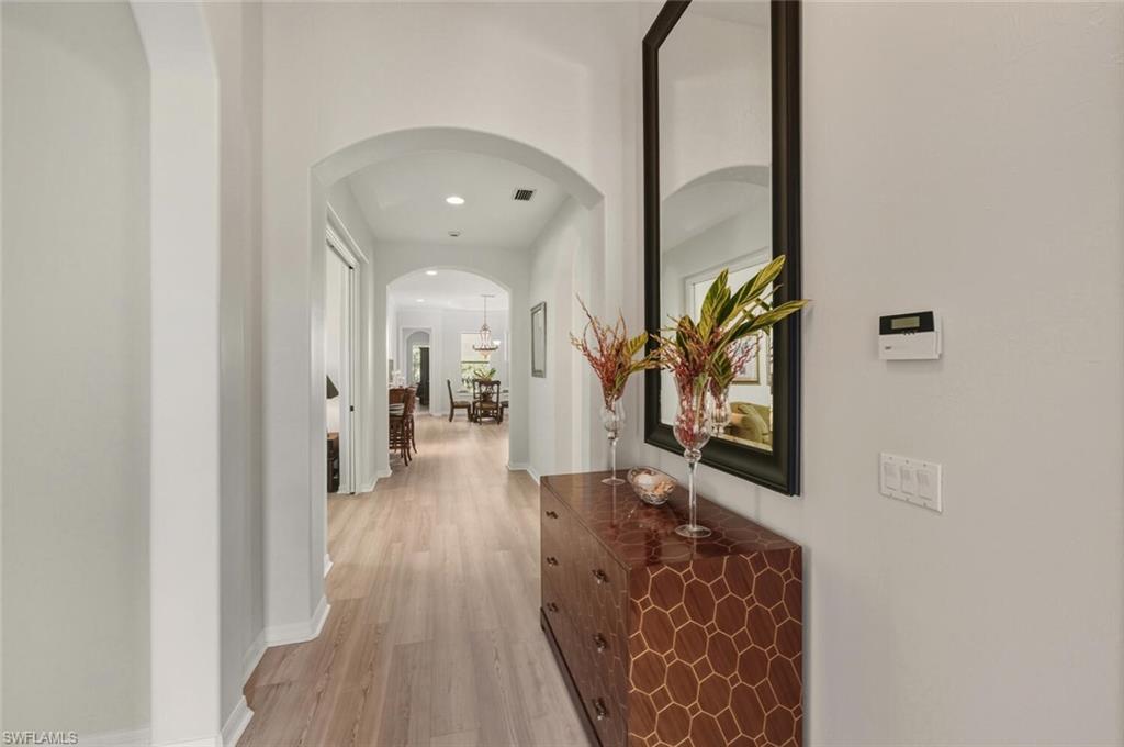 10800 Fieldfair Drive Naples, FL 34119 - Photo 4 of 47 Corridor featuring light wood-style flooring, arched walkways, and recessed lighting
