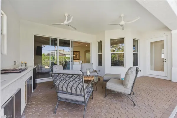 a backyard of a house with table and chairs potted plants