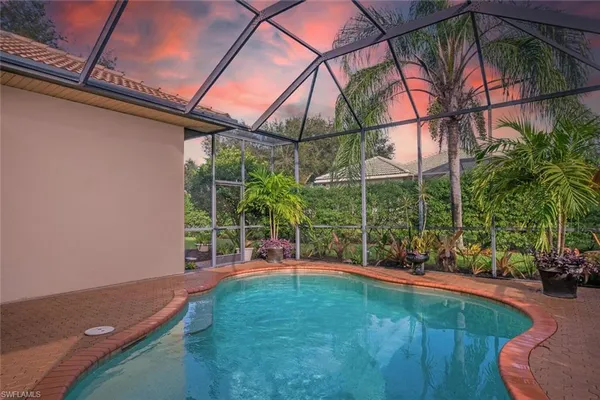 a view of a house with a yard and palm trees