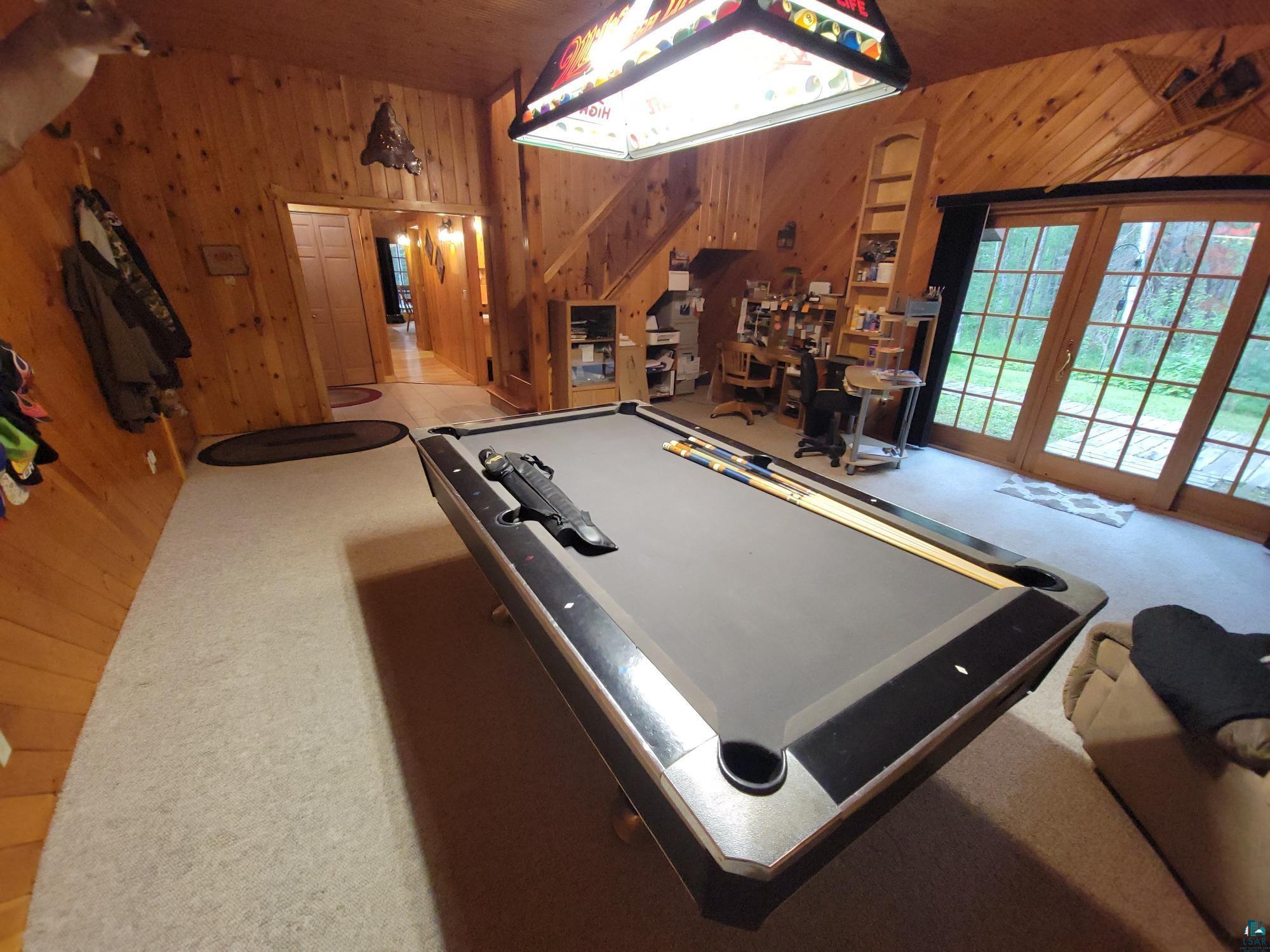 181 Linnell Road Grand Marais, MN 55604 - Photo 60 of 77 Wood-paneled walls and ceiling, exposed wood staircase, built-in shelving, glass-paned double doors, and a stained glass light fixture