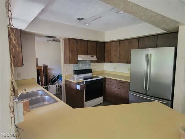 a kitchen with stainless steel appliances a refrigerator and a stove top oven