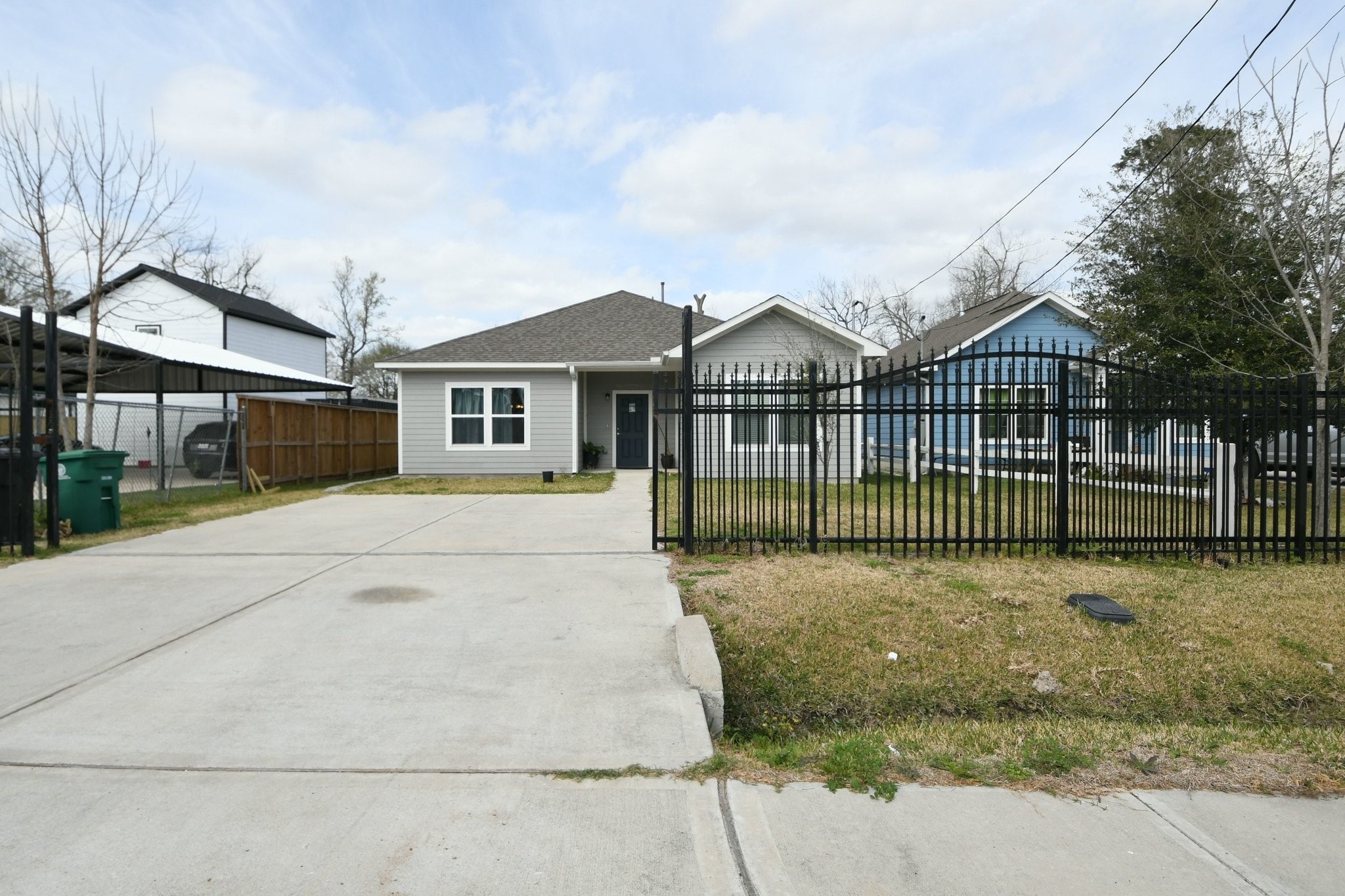 5817 Gaston Houston, TX 77016 - Photo 6 of 24 a view of a white house with a small yard and large trees