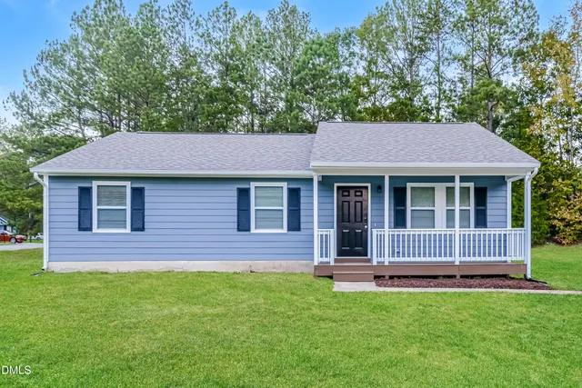 a brick house with a small yard and a large tree