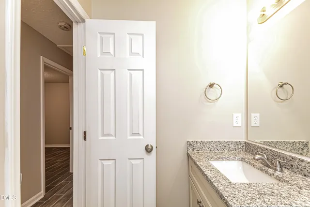 a bathroom with a granite countertop sink and a mirror
