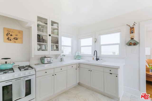 a kitchen with cabinets appliances a sink and a window