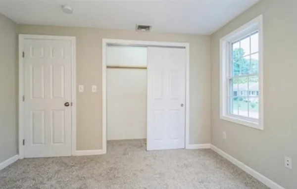 an empty room with windows and closet