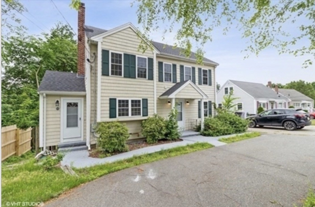 859 Pleasant Street Canton, MA 02021 - Photo 2 of 13 a front view of a house with a yard and garage