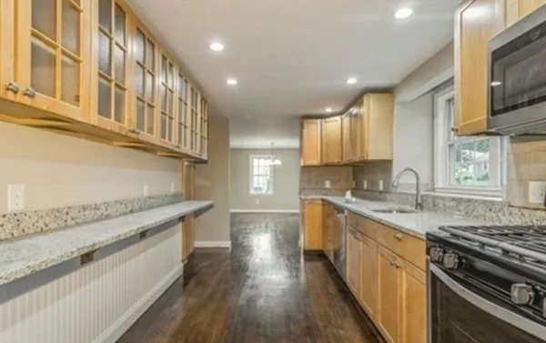 a large kitchen with stainless steel appliances granite countertop a lot of counter space and wooden floor