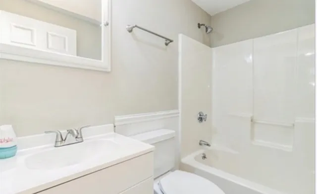 a bathroom with a sink toilet vanity and shower