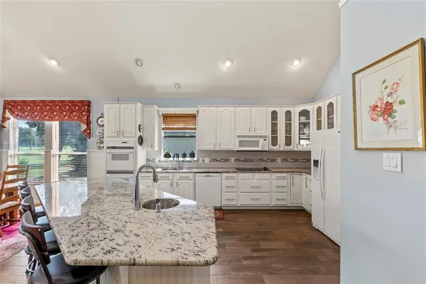 a kitchen with stainless steel appliances granite countertop a granite counter tops and a refrigerator