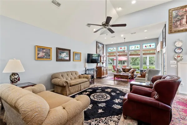 a living room with furniture ceiling fan and a large window