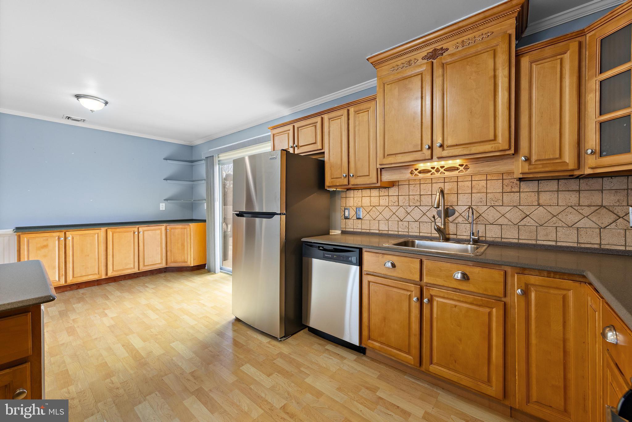 5 Fresno Street Barnegat, NJ 08005 - Photo 17 of 43 a kitchen with stainless steel appliances granite countertop a refrigerator a sink dishwasher and wooden cabinets with wooden floor