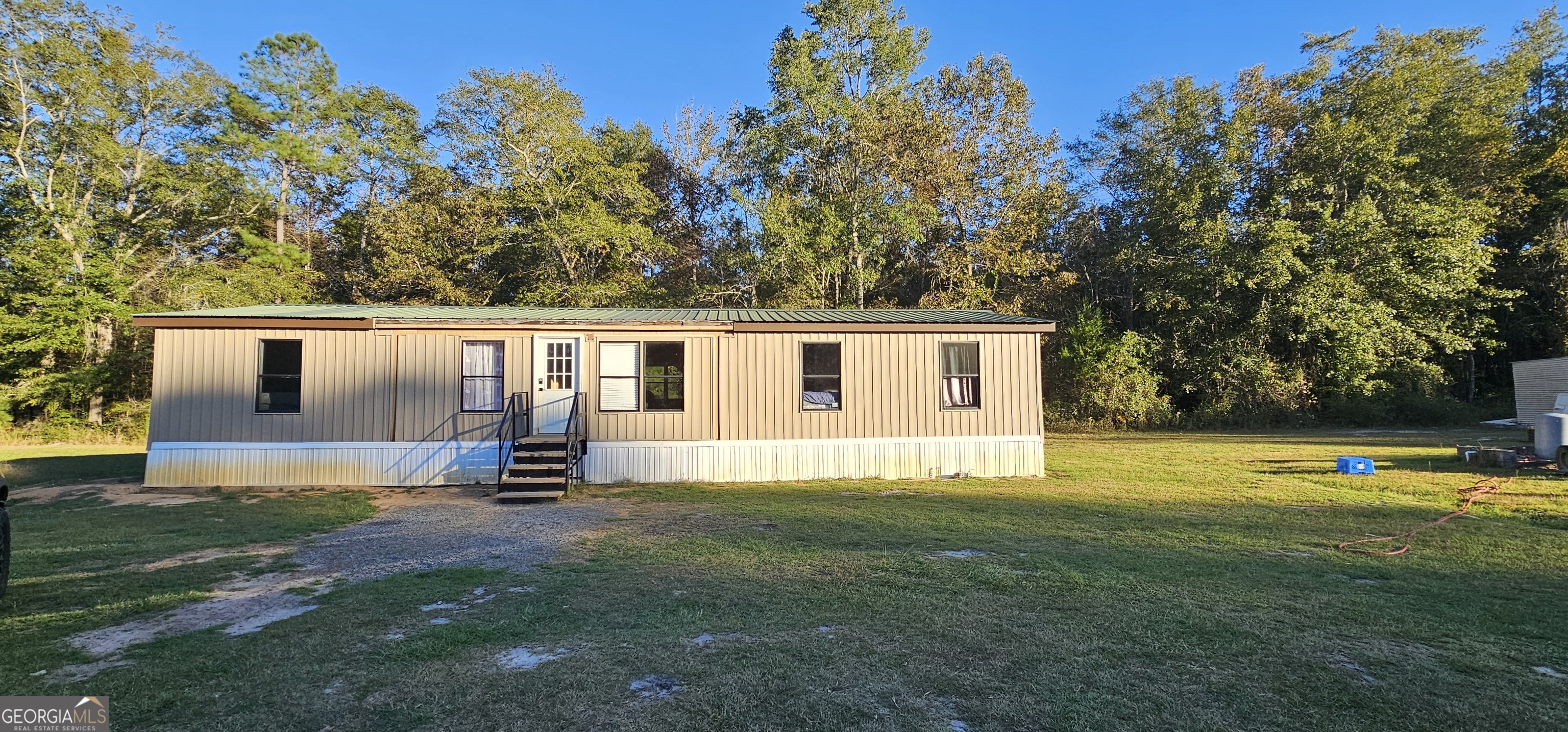 a view of a house with a backyard and a tree