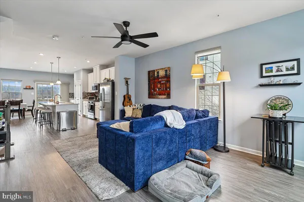 a living room with furniture and a view of kitchen
