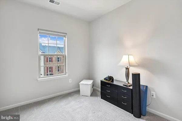 a spacious bedroom with a bed and a lamp on table