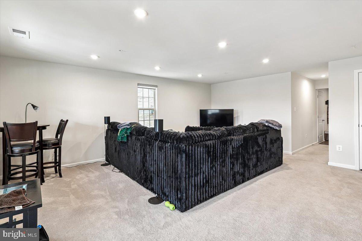 7838 Mine Run Road Hanover, MD 21076 - Photo 27 of 30 a living room with furniture a flat screen tv and a refrigerator