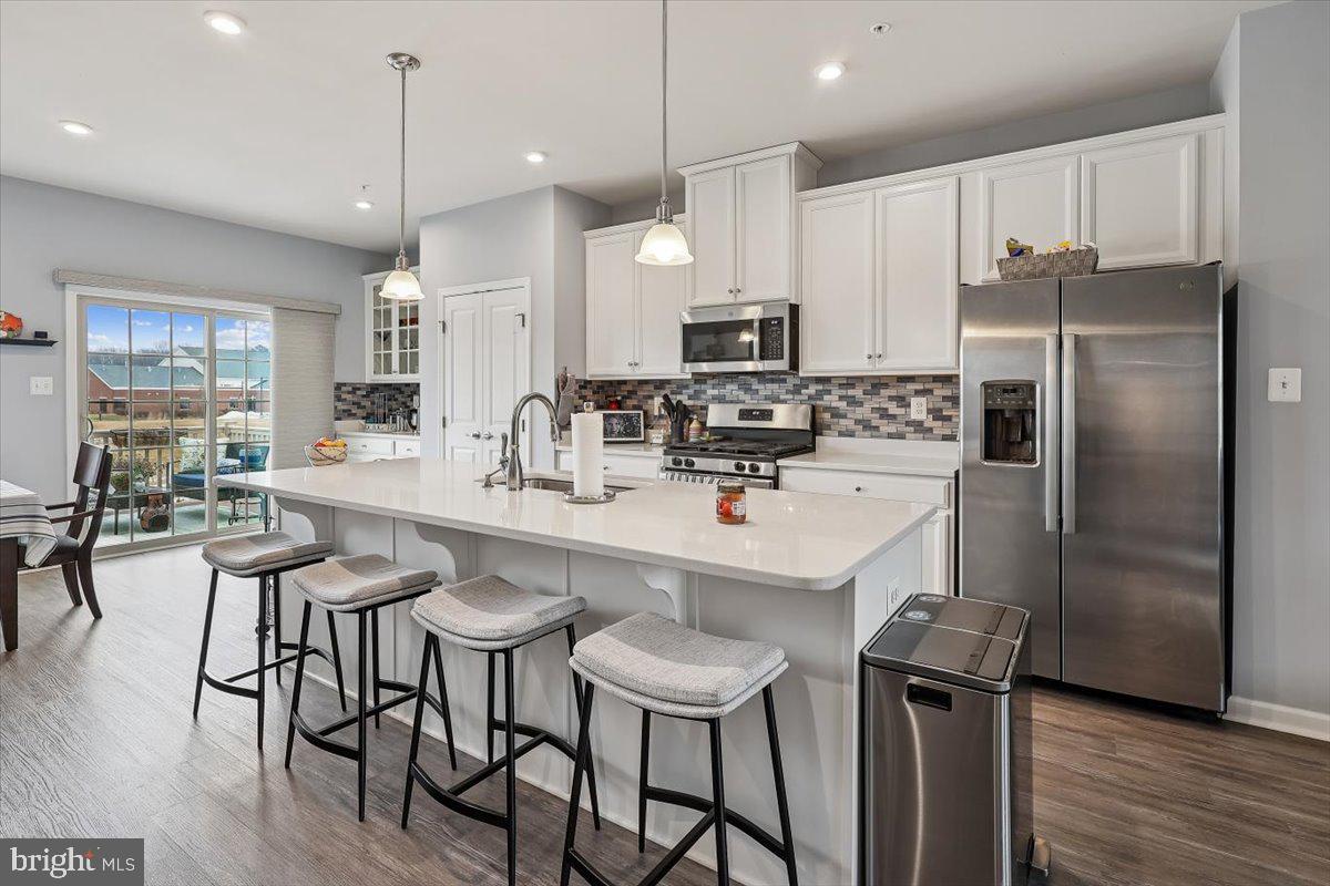7838 Mine Run Road Hanover, MD 21076 - Photo 4 of 30 a kitchen with stainless steel appliances a table chairs refrigerator and microwave