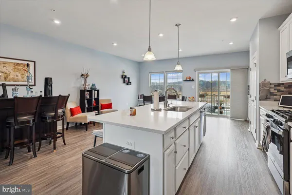 a kitchen with stainless steel appliances kitchen island wooden floors and view living room