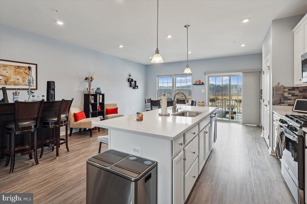 7838 Mine Run Road Hanover, MD 21076 - Photo 5 of 30 a kitchen with stainless steel appliances kitchen island wooden floors and view living room