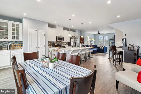 a dining room with stainless steel appliances kitchen island granite countertop a dining table chairs stove and kitchen view