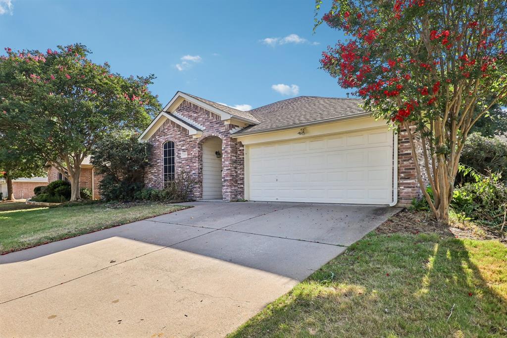 5609 Saddleback Road Arlington, TX 76017 - Photo 2 of 23 a front view of a house with a garden and trees