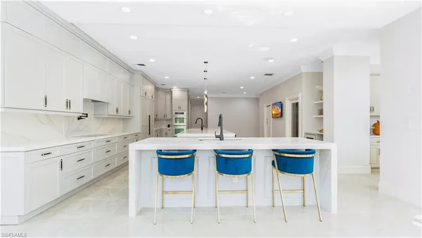 a kitchen with sink cabinets and chairs