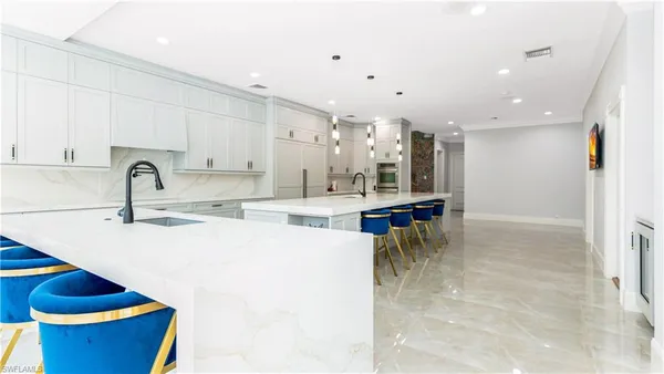 a kitchen with stainless steel appliances kitchen island granite countertop a sink and a refrigerator