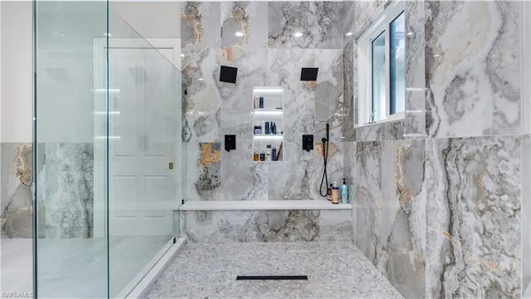 a spacious bathroom with double vanity sinks a mirror and a shower