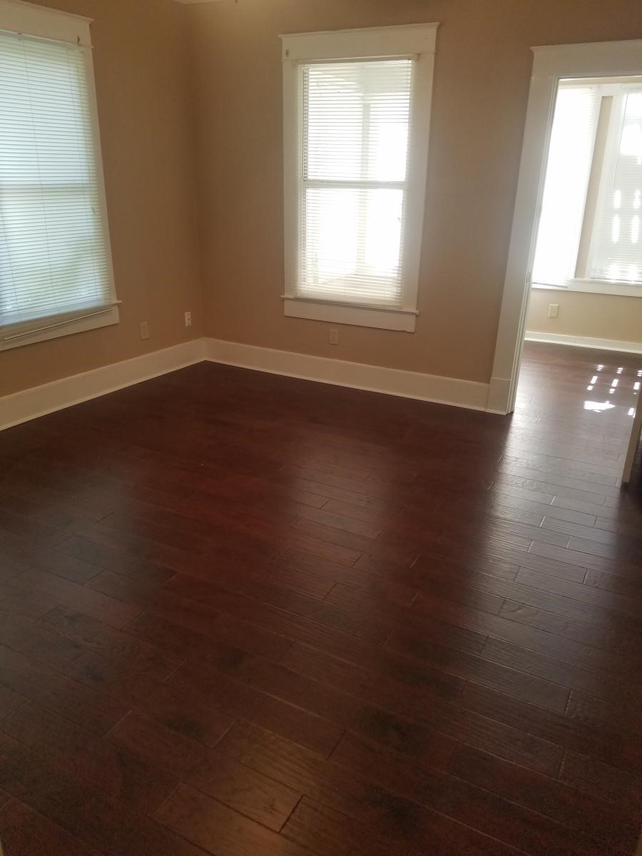 403 South 7th Street, Unit 1 Crockett, TX 75835 - Photo 4 of 8 an empty room with wooden floor and windows