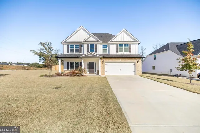 a front view of a house with a yard and lake view