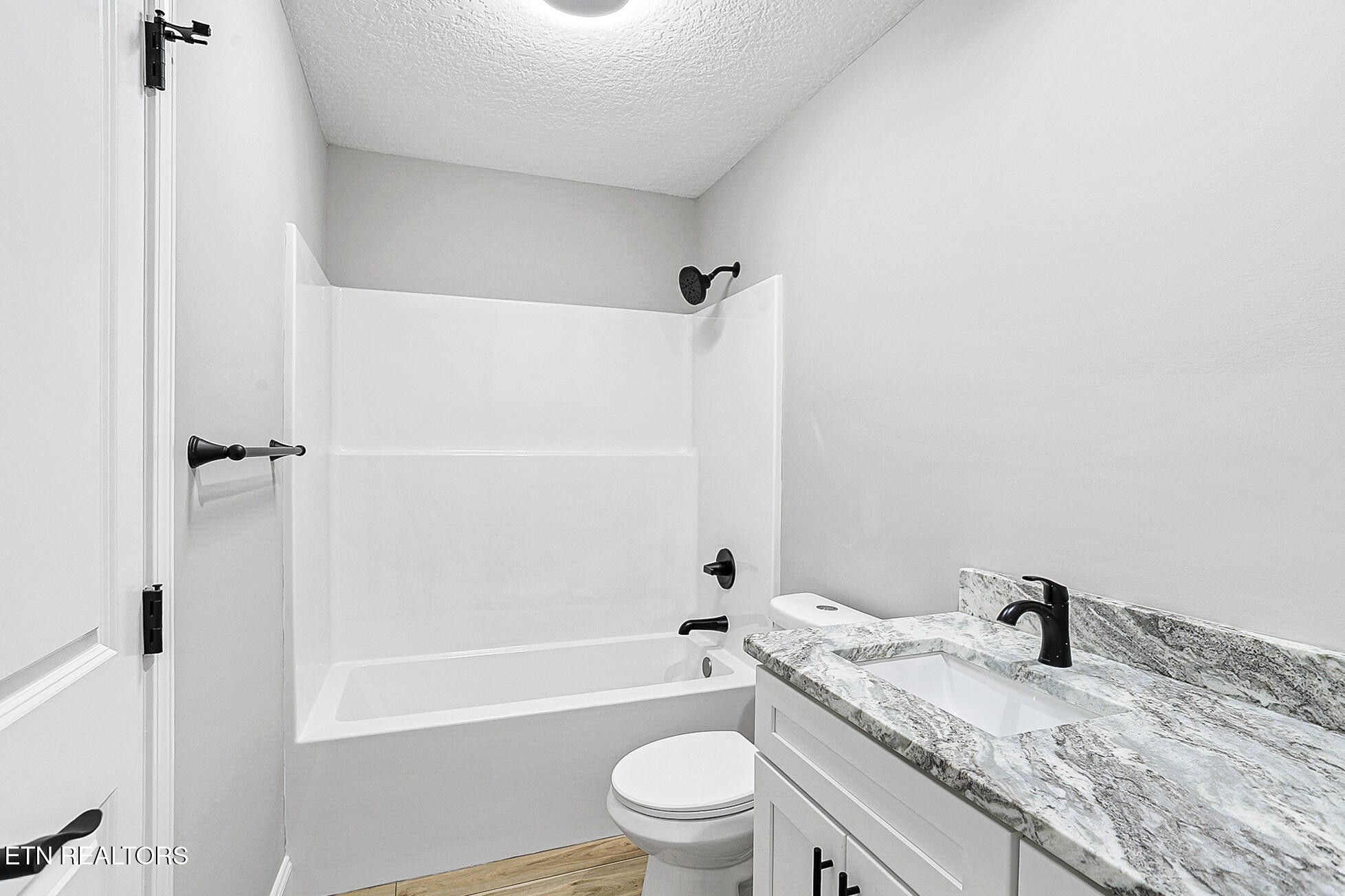 1134 Rider Avenue Knoxville, TN 37917 - Photo 35 of 44 a bathroom with a granite countertop toilet a sink and a bathtub