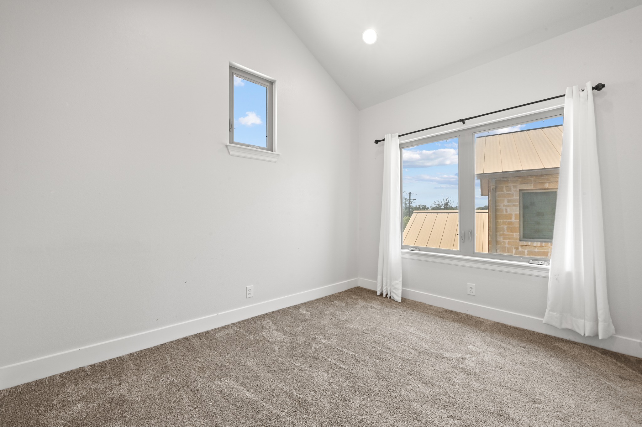 592 Farm To Market 967, Unit B Buda, TX 78610 - Photo 22 of 26 Bright and airy with vaulted ceilings and a large picture window, this versatile bedroom offers the perfect space for family, guests, or a dedicated home office.
