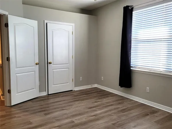 a view of an empty room with wooden floor