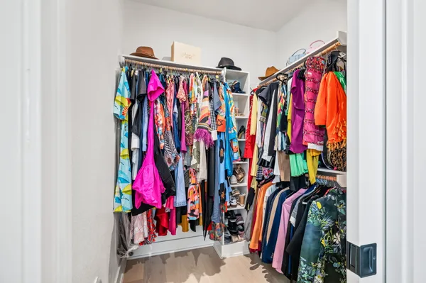 a view of walk in closet with clothes
