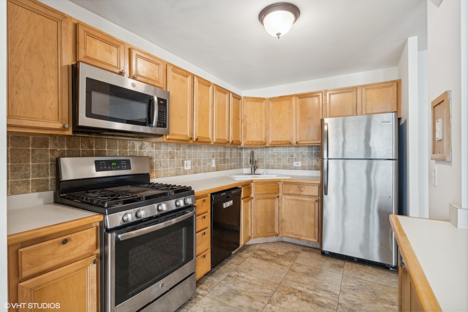 400 East Randolph Street, Unit 2525 Chicago, IL 60601 - Photo 8 of 23 a kitchen with granite countertop a refrigerator stove and microwave