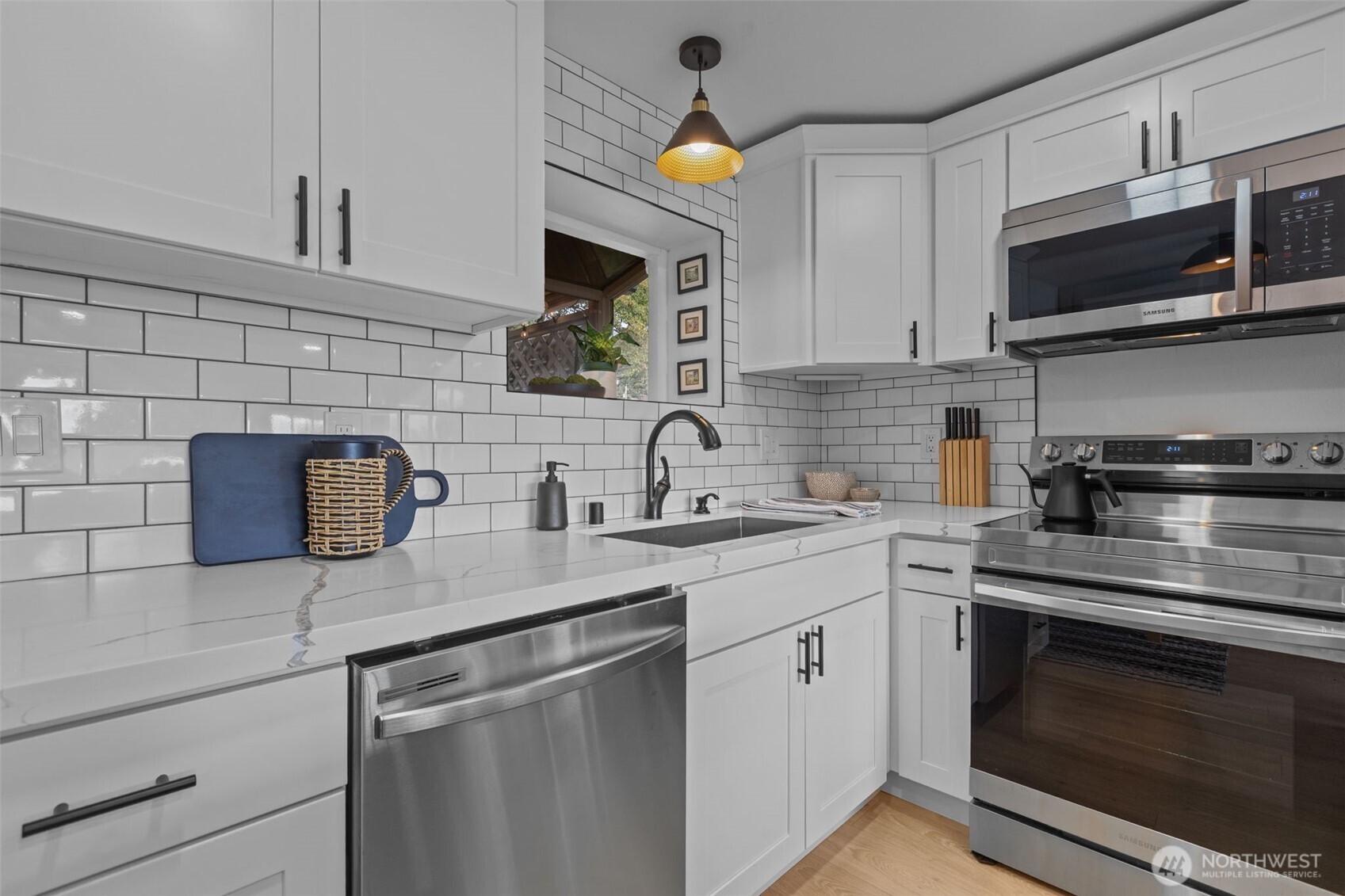 3610 Northeast 6th Street Renton, WA 98056 - Photo 21 of 33 a kitchen with stainless steel appliances granite countertop a sink stove a microwave and cabinets