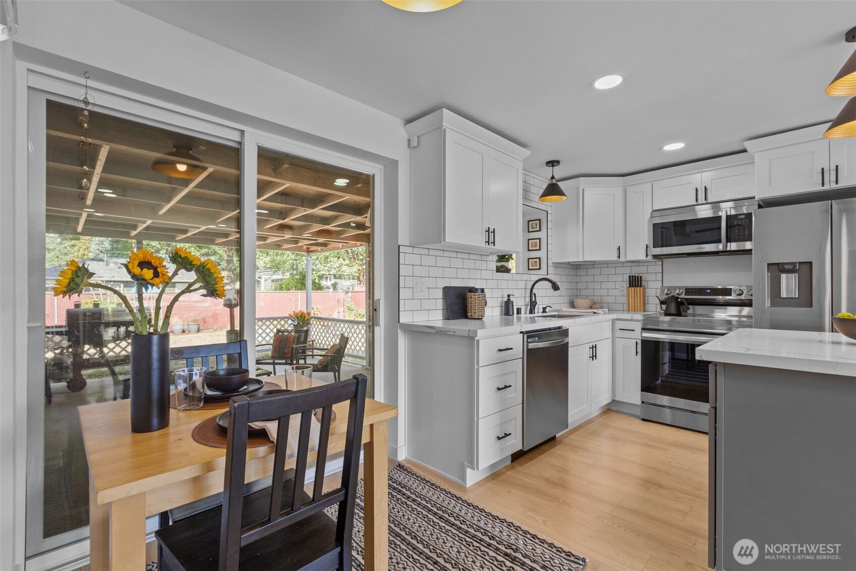 3610 Northeast 6th Street Renton, WA 98056 - Photo 6 of 33 a kitchen with stainless steel appliances granite countertop a stove top oven a sink dishwasher a refrigerator and a dining table with wooden floor
