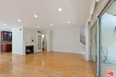 a view of an empty room with fireplace and a window