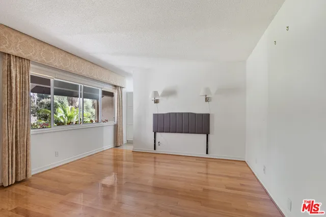en empty room with window and wooden floor