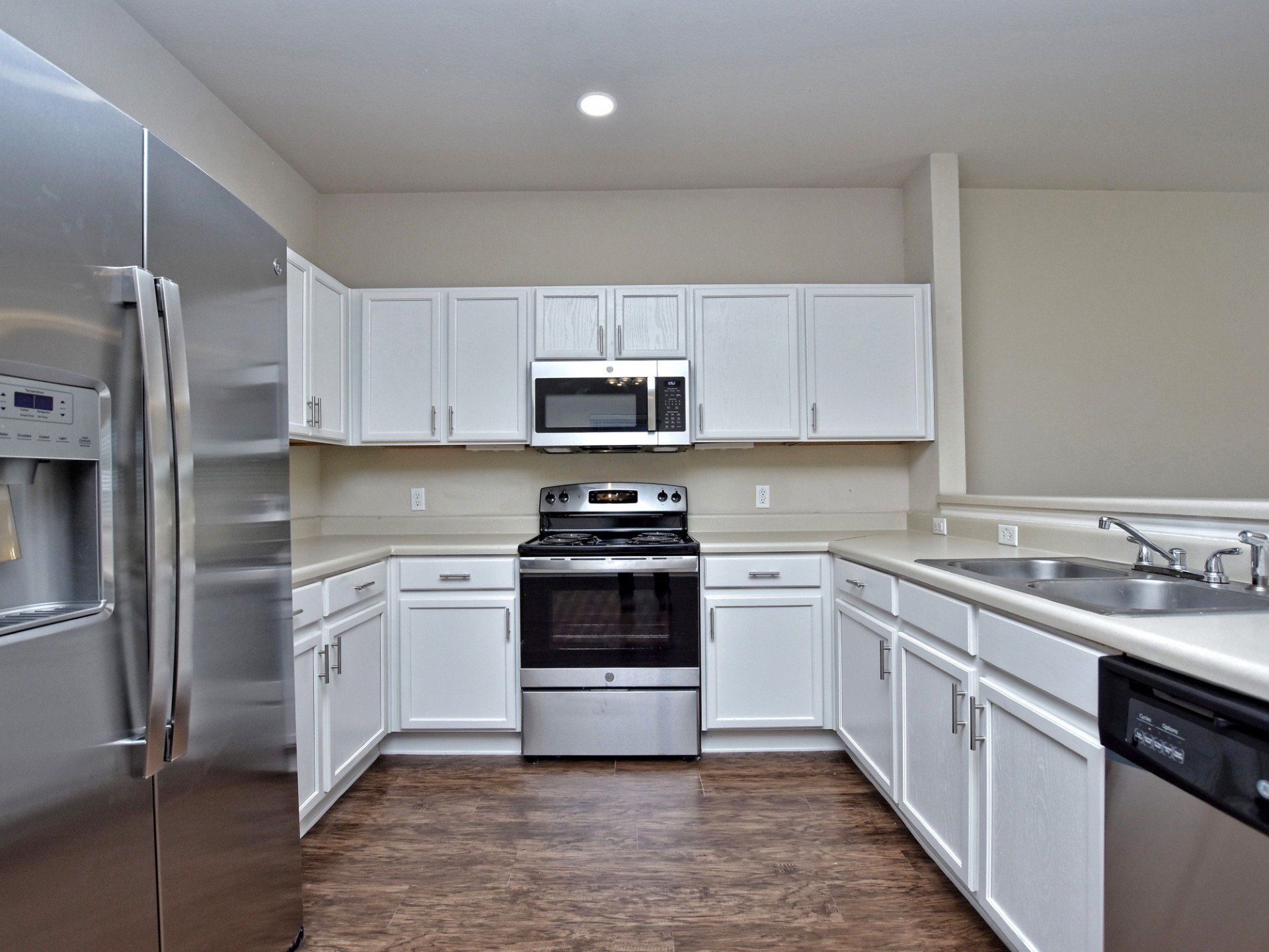 917 East 3rd Street Georgetown, TX 78626 - Photo 4 of 23 A well-appointed kitchen features white cabinetry and stainless steel appliances.