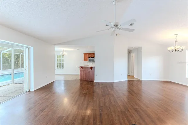 a view of a kitchen with wooden floor and a ceiling fan